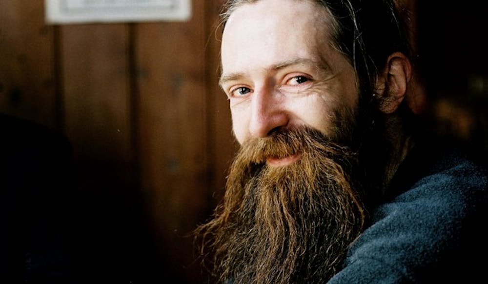 Longevity Summit Dublin 2025 keynote speaker portrait featuring a distinctive full beard and piercing eyes against an artistic neutral background