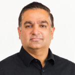 Dr. Amit Sharma, Group Lead in Senescence Immunology Research at SENS Research Foundation, smiling in a blue shirt outdoors.
